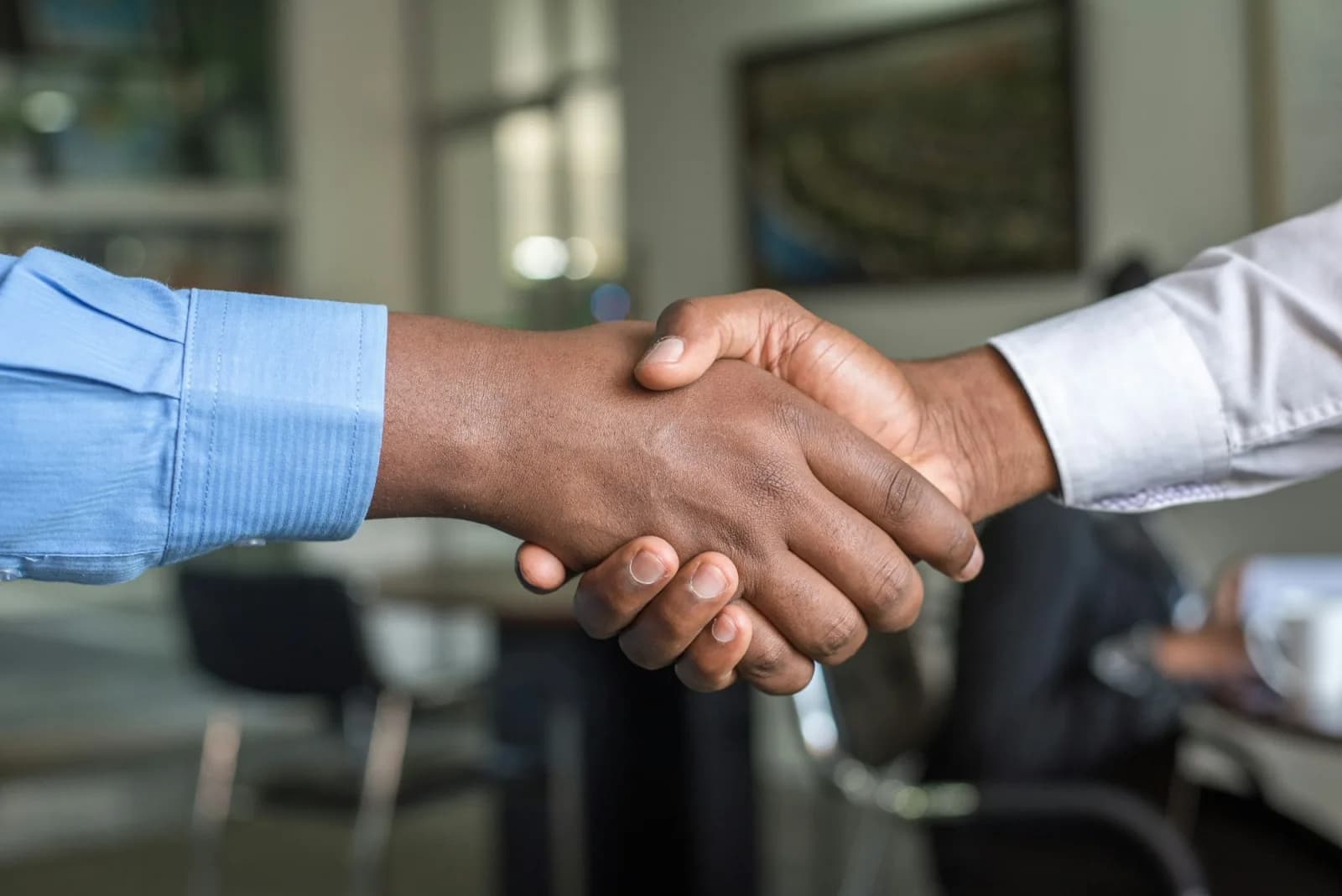 Poignée de main entre un courtier en crédit et un apporteur d'affaires scellant un partenariat